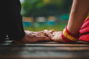 A couple holding hands on a bench