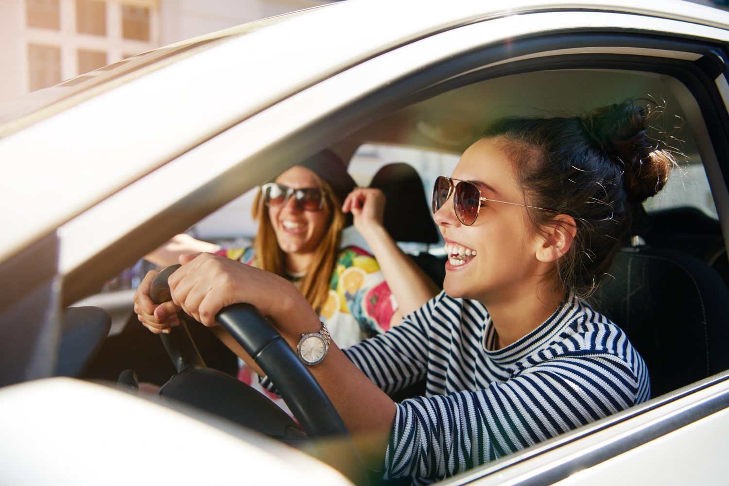 teen driver with a passenger laughing